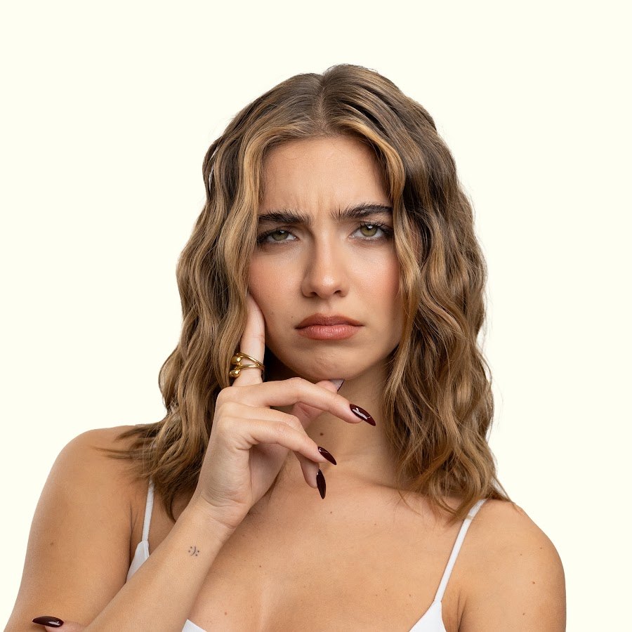 Alessia Lanza guarda in camera con la mano appoggiata al viso, capelli mossi