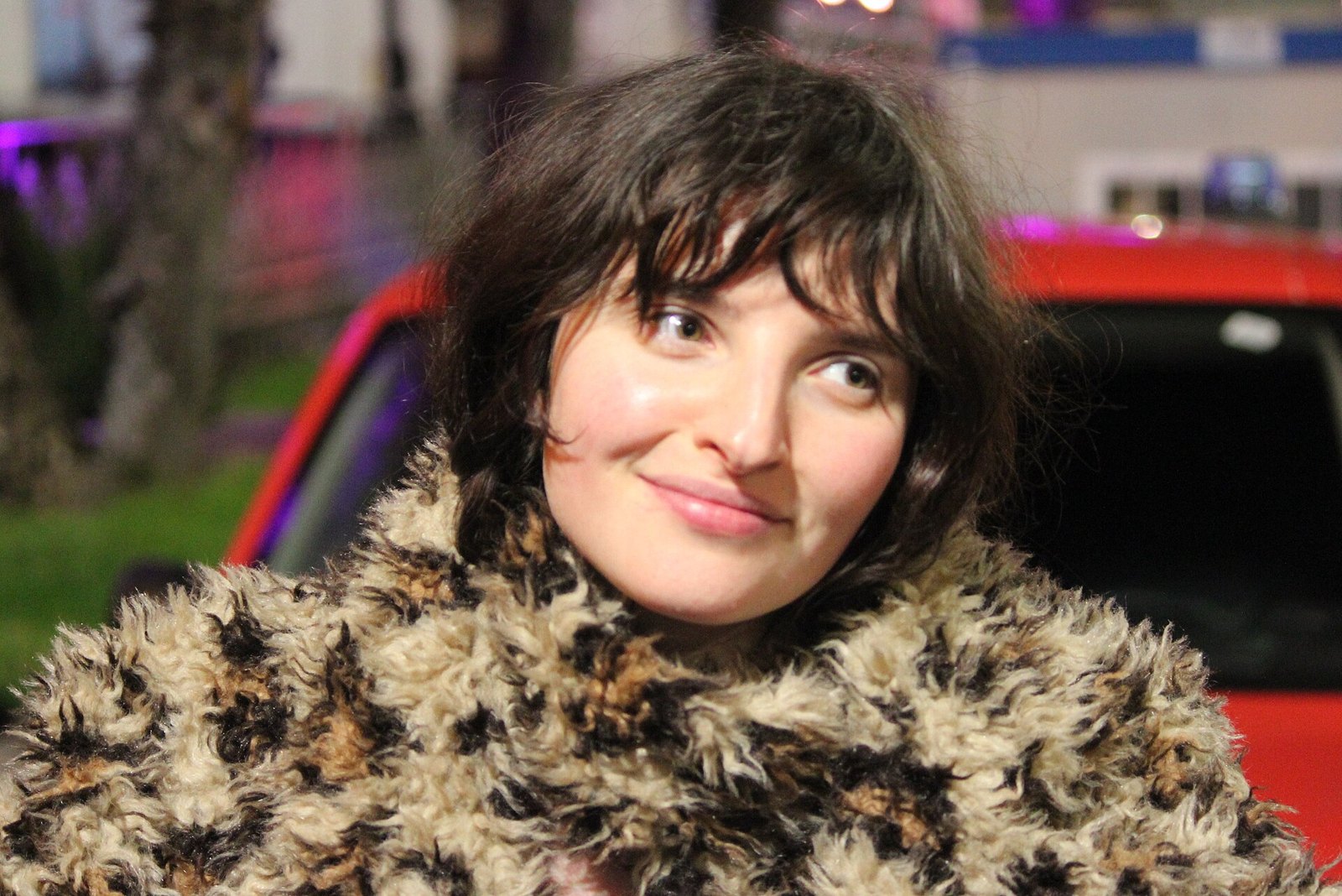 Angelica Bove sorride, capelli scuri e cappotto di pelliccia sintetica