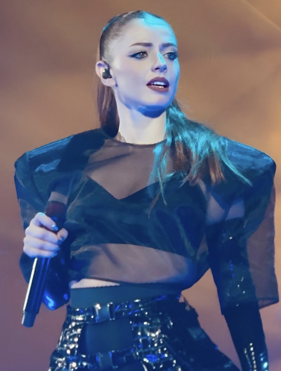 Annalisa canta sul palco con il microfono in mano, illuminata da una luce blu