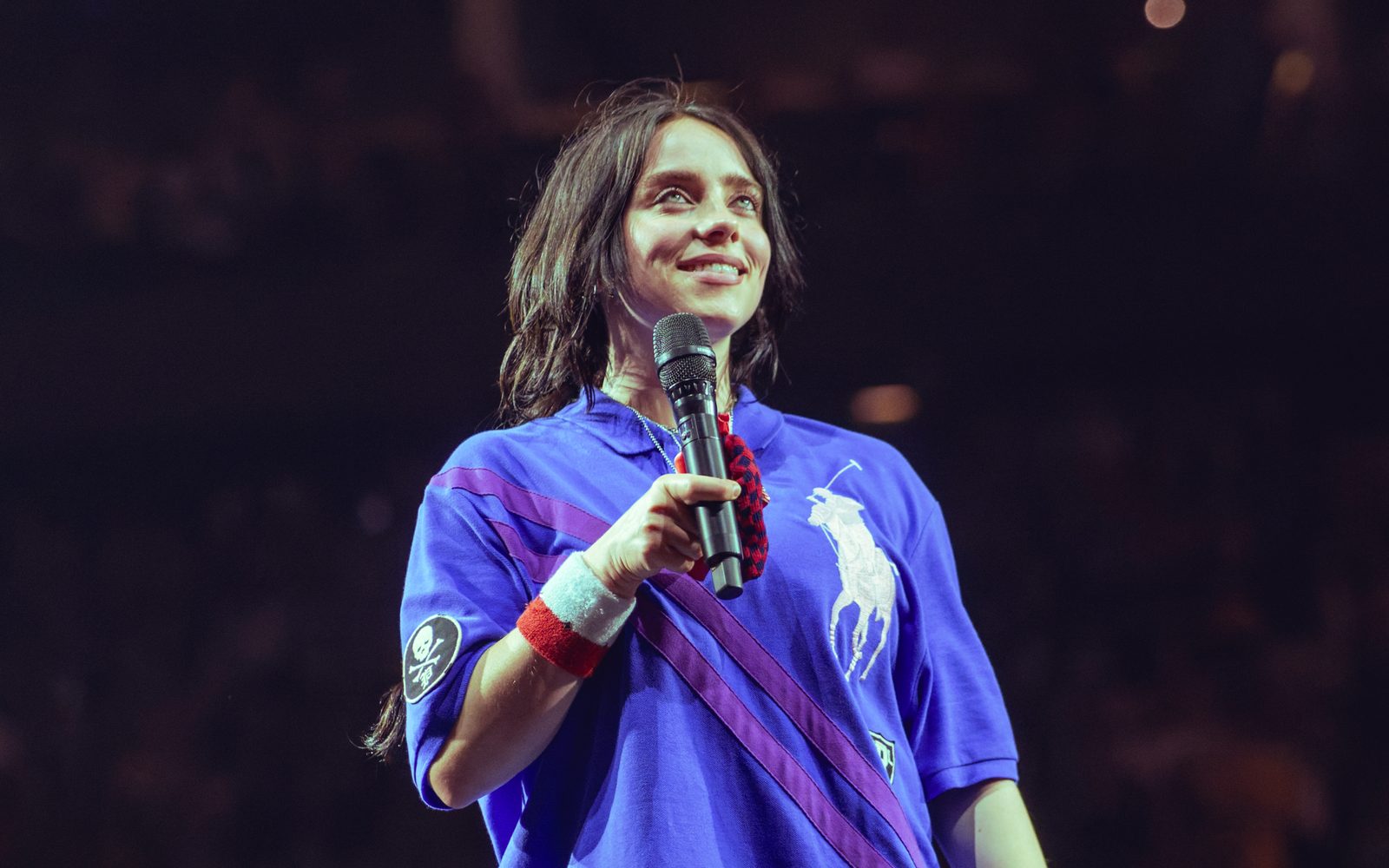 Billie Eilish sorride sul palco con il microfono in mano