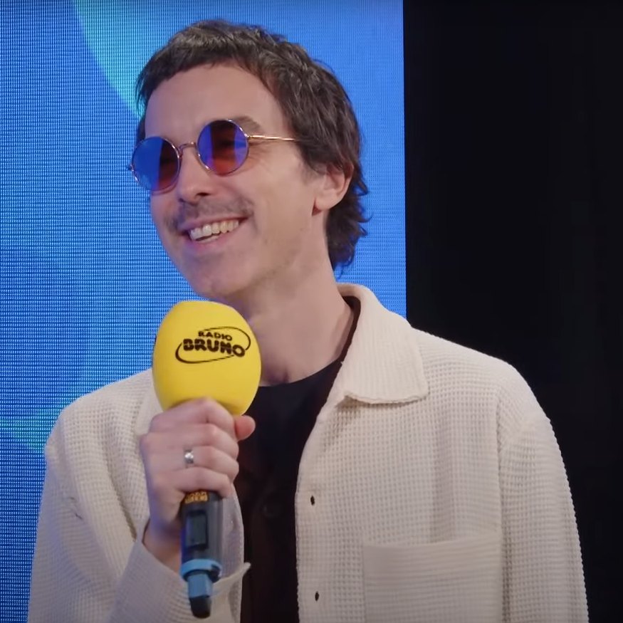 Diodato sorride con occhiali da sole tondi durante un'intervista