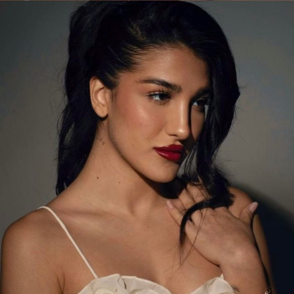 Eléna Hazinah in primo piano, capelli scuri e rossetto rosso