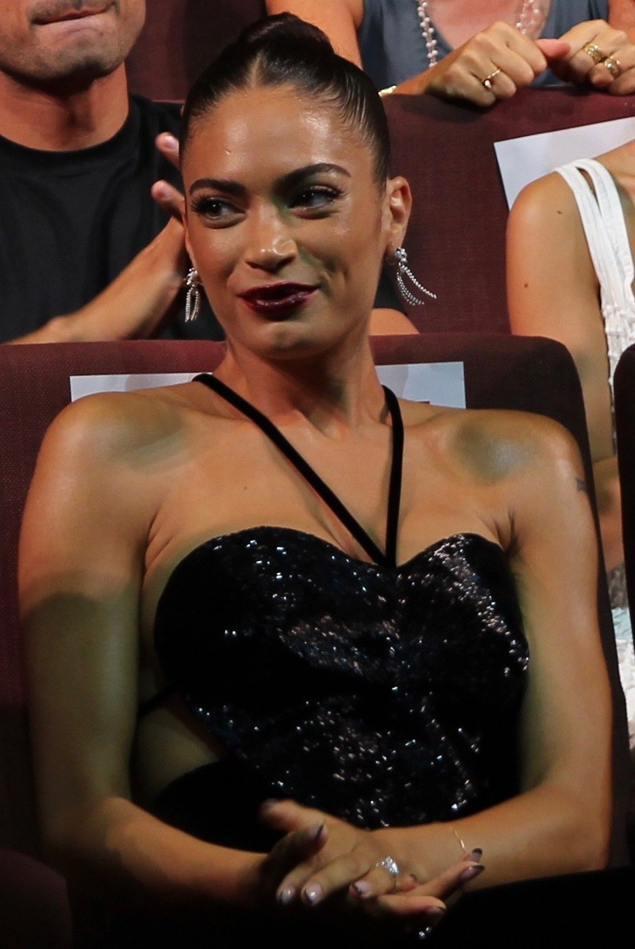 Elodie sorride seduta in platea alla Mostra del cinema di Venezia, con un abito nero