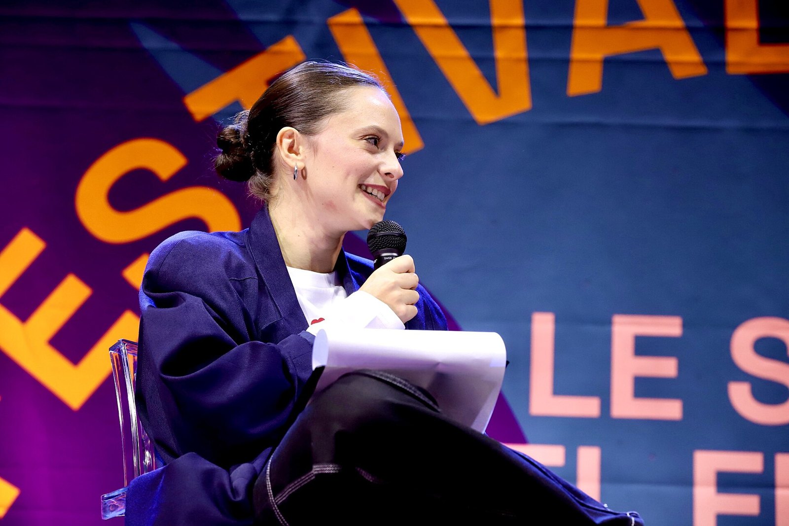 Francesca Michielin sorride con il microfono in mano, seduta sul palco