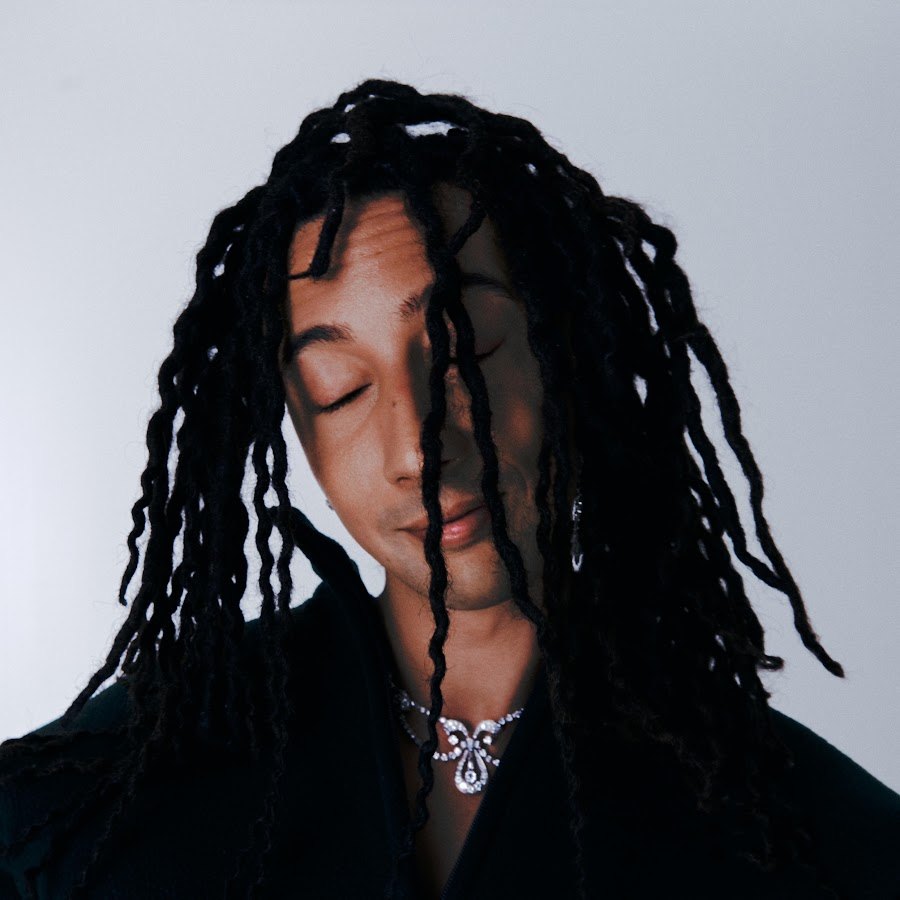 Ghali in un ritratto in primo piano, con le lunghe treccine che gli scendono sul viso