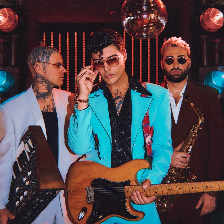 Stash dei The Kolors con occhiali da sole e giacca azzurra, insieme agli altri due componenti della band