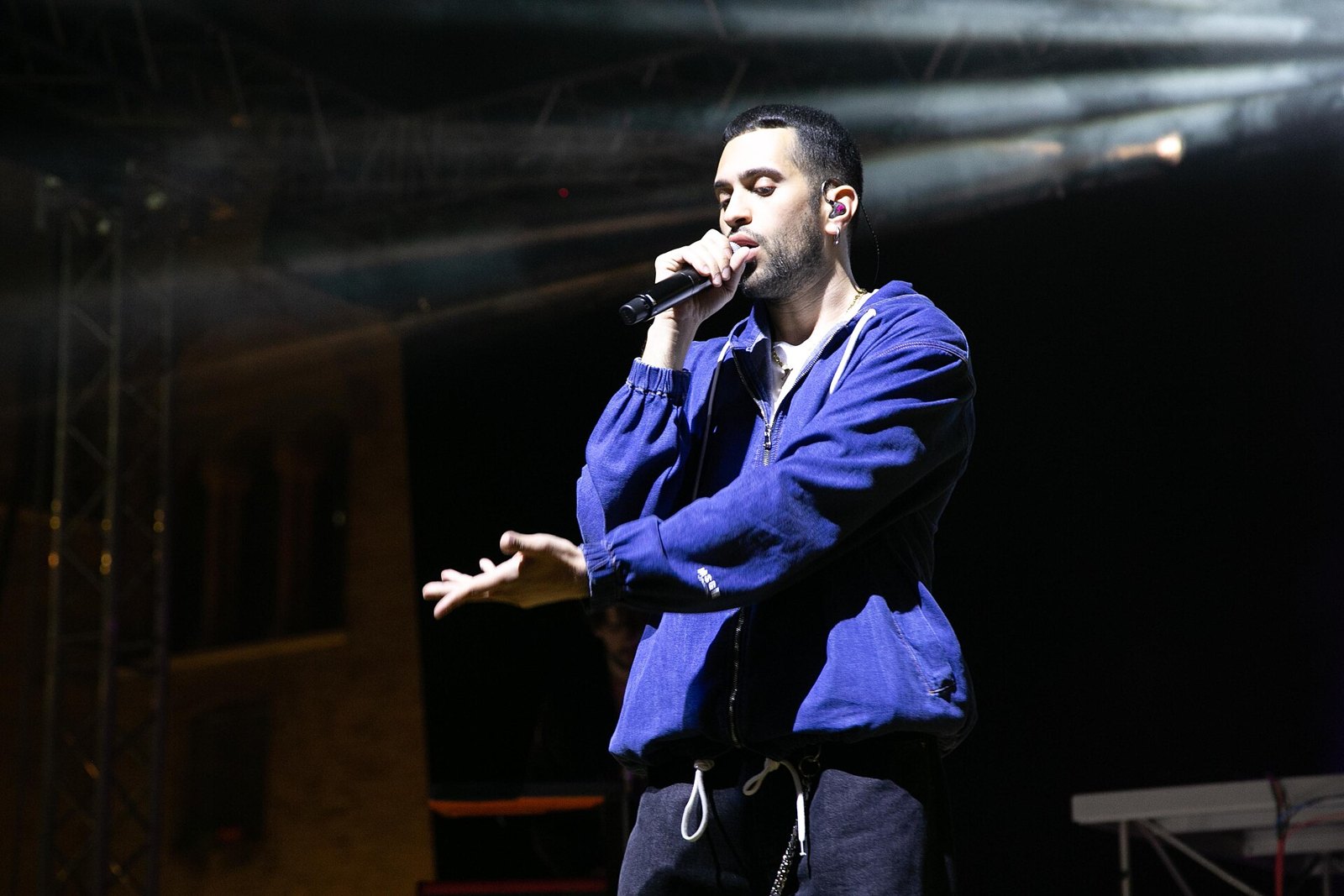Mahmood canta al microfono sul palco con una felpa blu