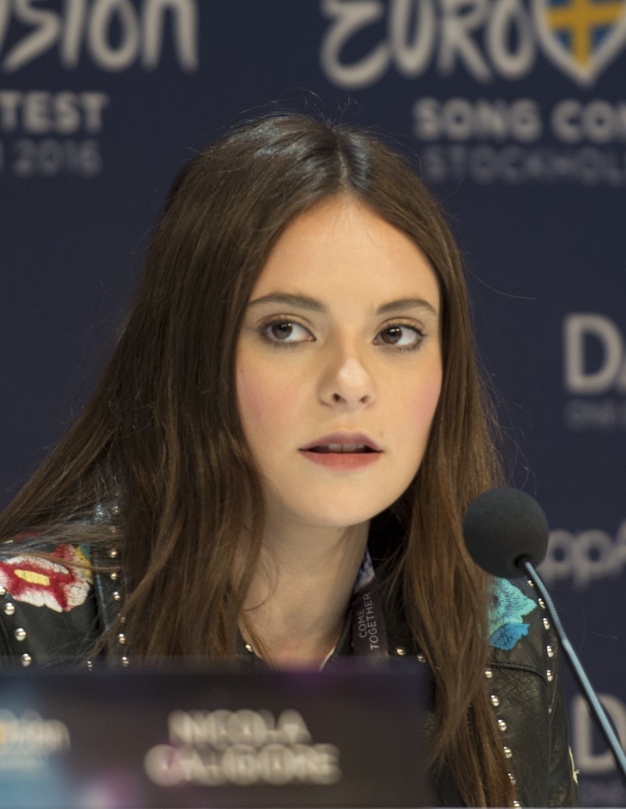 Francesca Michielin con i capelli lunghi sciolti e una giacca di pelle, davanti a un microfono