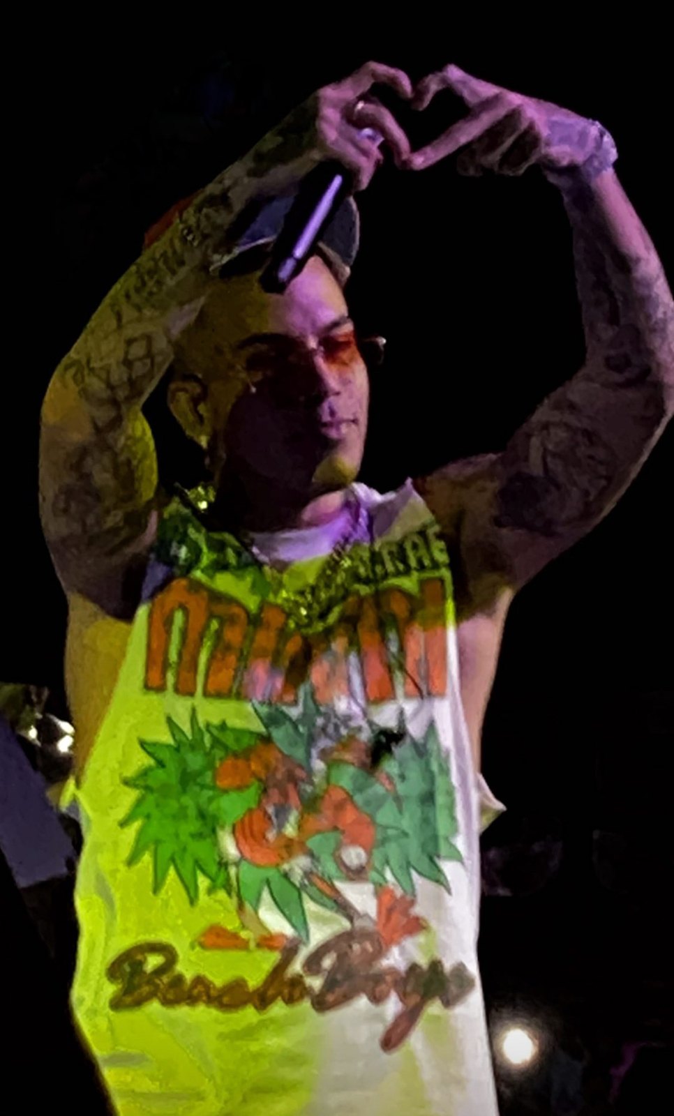 Sfera Ebbasta sul palco fa un cuore con le mani sopra la testa